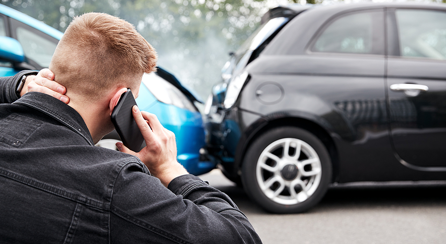 Young Male Motorist Involved In Car Accident Calling Insurance Company 